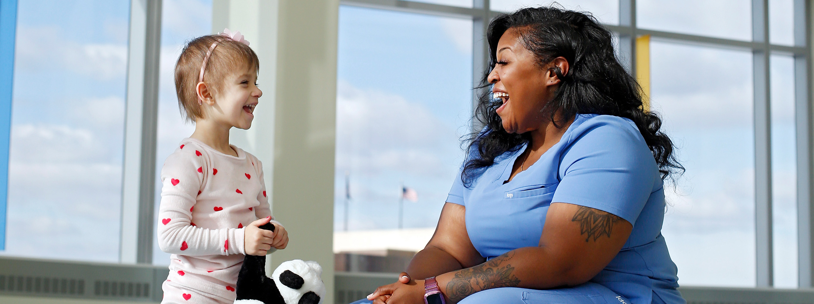 Nurse holding young smiling infant